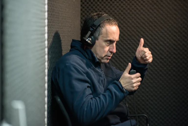 Paciente en cabina audiométrica levantando la mano al escuchar un tono